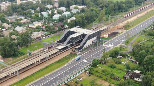 Drone rising backward above station and railway tracks