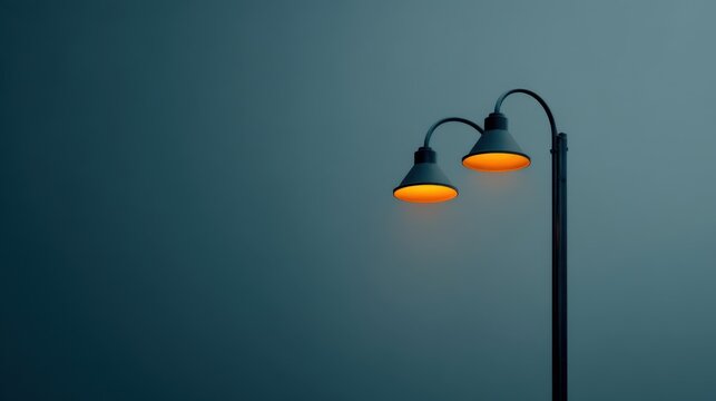 Elegant street lamp with a warm yellow glow illuminating a serene urban backdrop under a soft blue and gray gradient sky at dusk