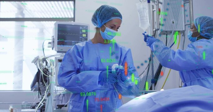 Holding airway tube, surgeon treating patient in OR with monitor and IV pole, wearing blue gowns