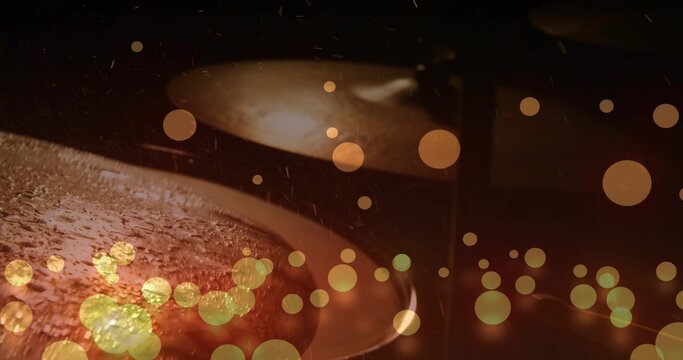 Shimmering front drum cymbal showing droplets with rear cymbal blur on stage, with stand and bokeh