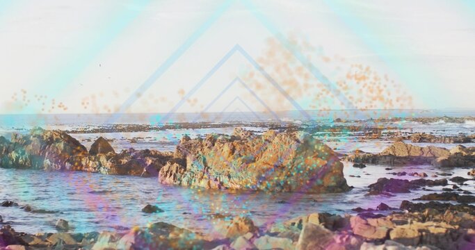 Dominating large jagged rock formation glistening at rocky tidal shoreline, with triangle overlay