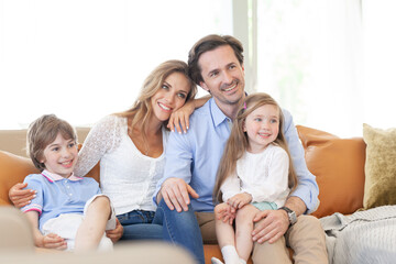 Obraz premium A happy family is sitting on the couch watching TV