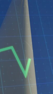 Vertical video: Cam tilting down wind turbine blades turning green graph moving tech checking door