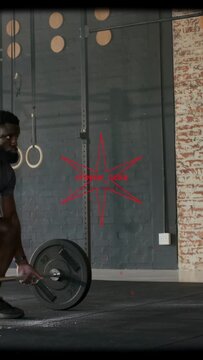 Vertical video: Male athlete initiating loaded barbell lift gripping chalk driving legs for fitness