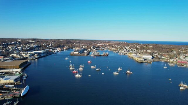 Smooth tilted up drone fly toward the Inner Harbor with anchored boats at Jodrey State Fish Pier, Gloucester, Massachusetts, US