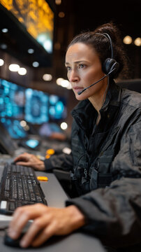 Focused Command Center Operator: A dedicated operator, deeply engrossed in her task, navigates complex systems, her eyes fixed on intricate data displays.