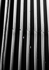 Obraz premium Corrugated metal surfaces create a rhythmic pattern of shadows and highlights.