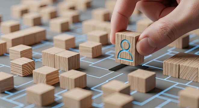Hand placing wooden person block into digital grid gap