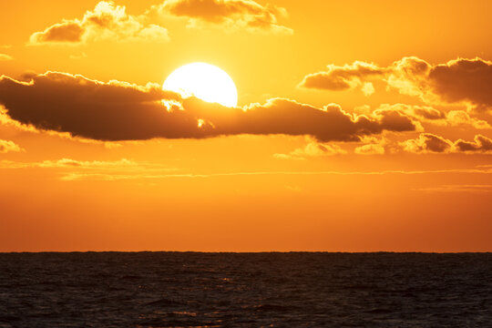 Sunrise on black sea. Clear water and sun behind clouds.