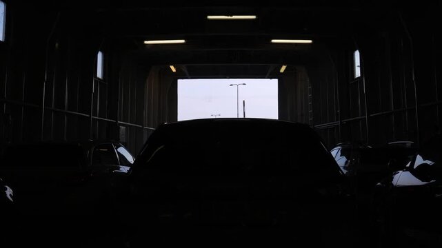 Cars turning on back lights in a dark room, preparing to drive off