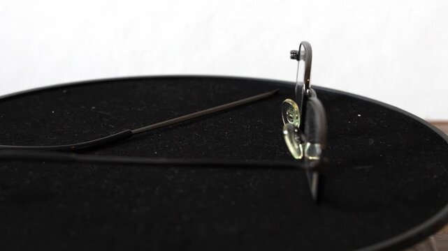 Broken old glasses with missing temple, close up detail