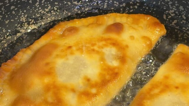 meat-filled pastries are fried in boiling oil