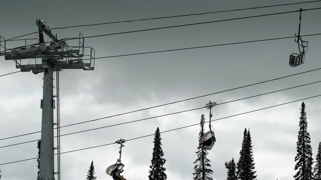 Skier riding chairlift in winter ski resort transport over snowy mountain landscape under cloudy sky outdoor.