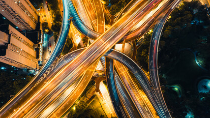 Aerial view of highway interchange at night with light trails and urban traffic © Danko Creative