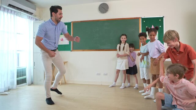 Diverse group of school children enjoying dance activity with teacher in an international classroom, encouraging active learning and teamwork