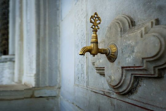 Antique brass faucet on ablution fountain in Ottoman mosque, Istanbul, Turkey	