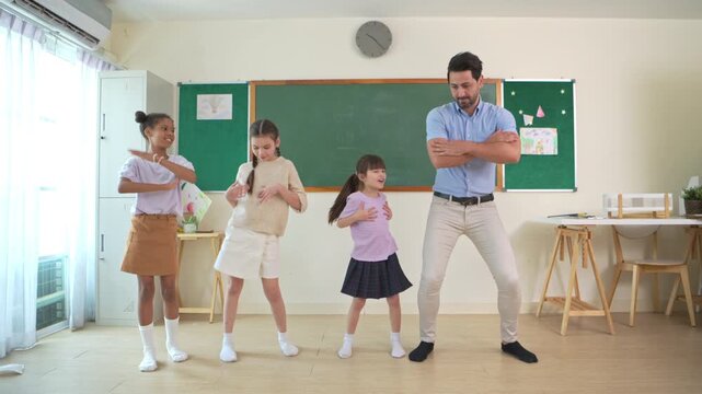 Diverse group of school children enjoying dance activity with teacher in an international classroom, encouraging active learning and teamwork