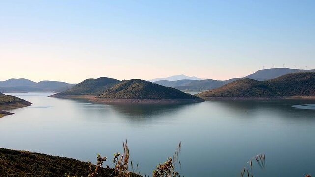 Static shot footage from high angle of a beautiful lake with calm blue water and mountains in the horizon in Boeotia-Greece.