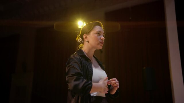 Passionate female vocalist performing under dramatic stage lighting, expressing emotion through music and movement during an intimate live concert