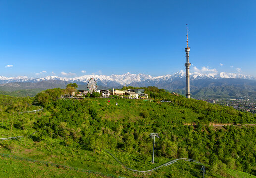 Mount Kok Tobe (Blue Hill) with the famous TV tower against the backdrop of the Zailiyskiy Alatau mountain range in the Kazakh city of Almaty on an  spring evening