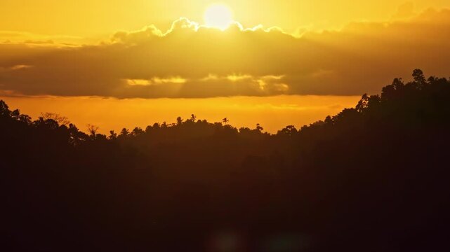 Golden hour sun behind clouds over jungle mountains in Sogod Bay Leyte