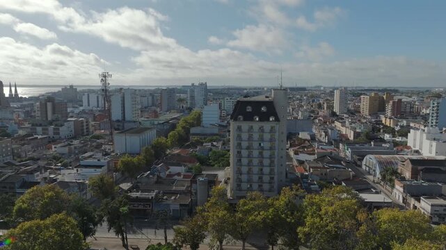 Panoramic drone orbit over Rio Grande downtown reveals European style mansard building cathedral spires city park and Lagoa dos Patos