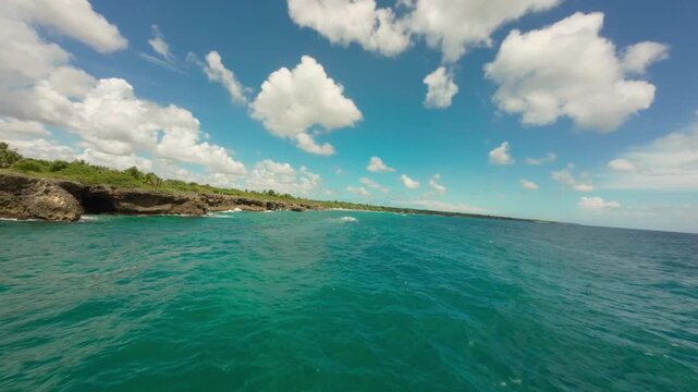 FPV drone flying over surface of turquoise sea in Boca de Yuma, Dominican Republic. Aerial forward, copy space