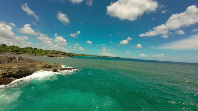 FPV drone shot flying over line where murky Yuma river meets turquoise Caribbean sea in Boca de Yuma. Aerial