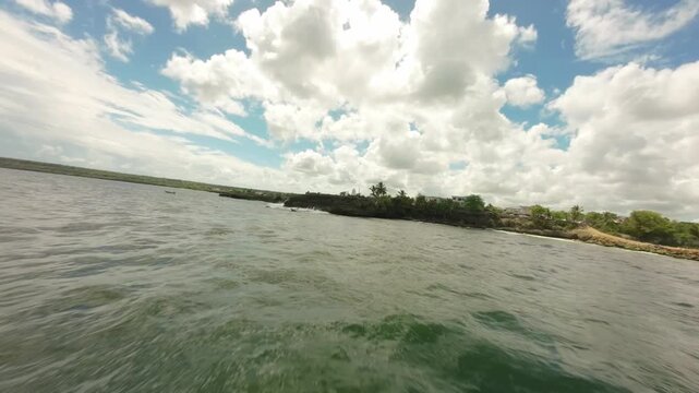 FPV drone shot flying low over sea along rocky coast of Boca de Yuma, Dominican Republic. Aerial, copy space