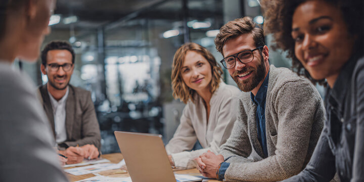 Busy modern office environment with diverse business people multitasking, collaborating, team members using laptops, smartphones and documents, networking and communication.