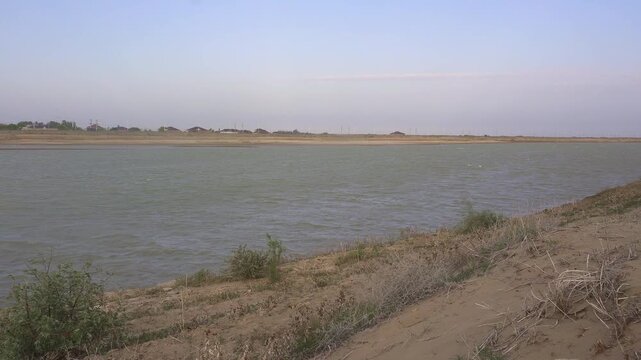 Syr Darya riverbank with a view of residential houses in the background, Kyzylorda, Kazakhstan.