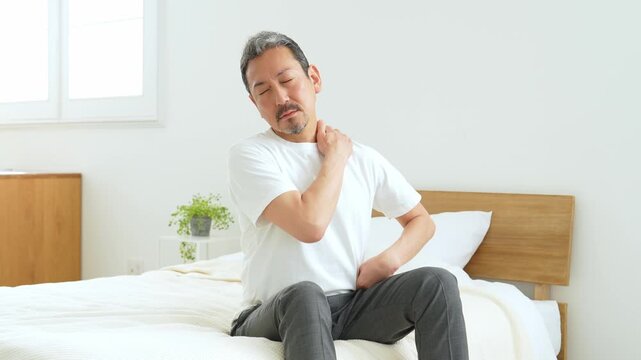 肩と腰のマッサージをする中高年男性