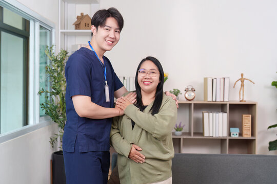 Asian man caregiver and woman patient smiling in home healthcare setting