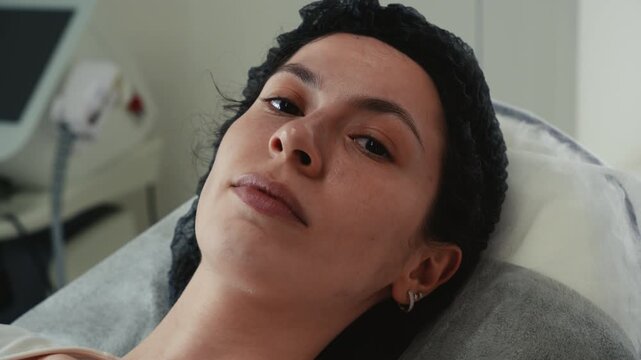 Close up of young woman showing facial expressions to cosmetologist before cosmetic injection procedure. Facial movement analysis for aesthetic treatment planning in beauty clinic. Skincare, anti