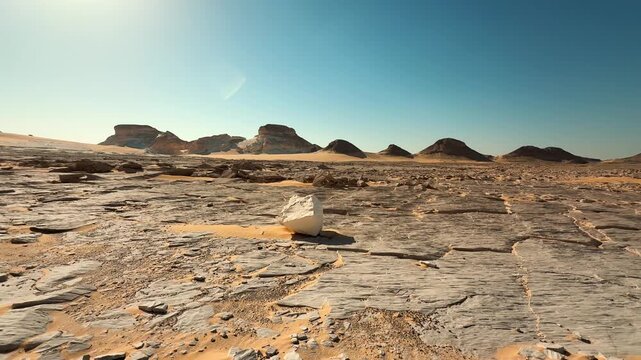 Low angle wide shot of desert stone ground with hills on horizon. Cinematic slider motion