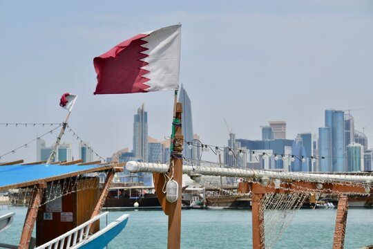 Flag of Qatar flies in wind on Doha dhow