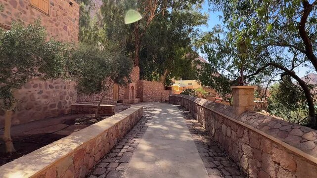Pov walk along stone path inside Saint Catherine Monastery courtyard