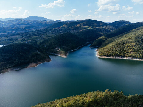 Aerial view of Rovni Lake reservoir and surrounding hilly landscape in Serbia. g.