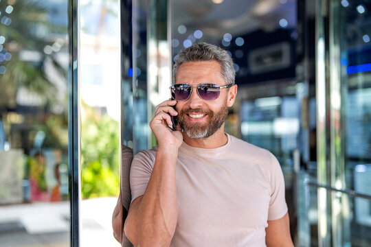 Casual businessman talking on phone outdoor. Businessman using phone. Man phone conversation. Hispanic business man with smartphone. Business communication. Man reply incoming phone call