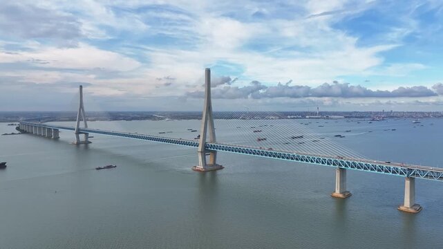 The aerial footage of the Shanghai-Suzhou-Nantong Yangtze River Bridge and the bustling cargo ships passing through the Yangtze River presents a magnificent and breathtaking view