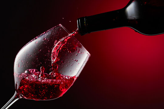 Red wine is poured from a bottle into a glass.