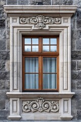 Fototapeta premium Ornate carved stone window frame on old building facade