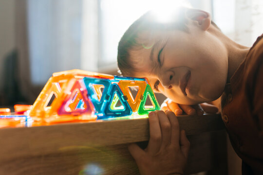 Child playing indoors with a colorful magnetic constructor toy