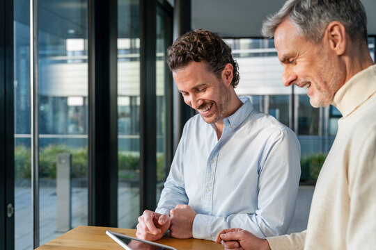 Two men in an office having a business meeting with a tablet