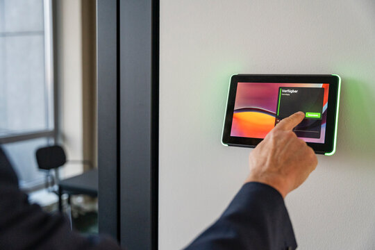 Man using a tablet to book an office in a modern workspace