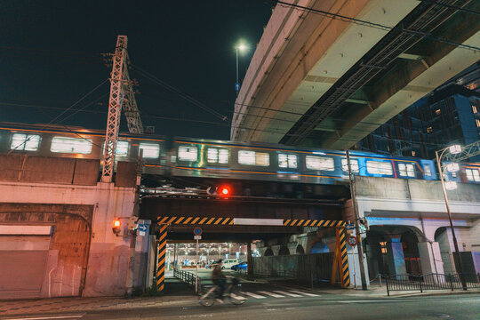 Moving train on a railway bridge at night in Osaka Japan