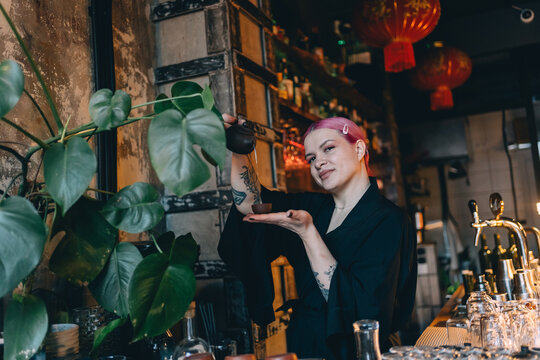 Smiling bartender pouring tea in a Japanese style bar