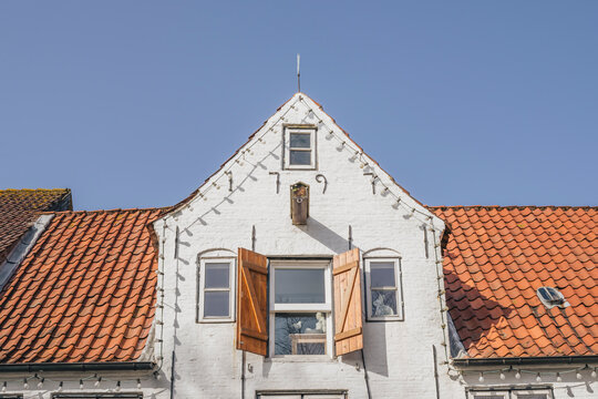 Historic white house facade with gable under blue sky in T�nning