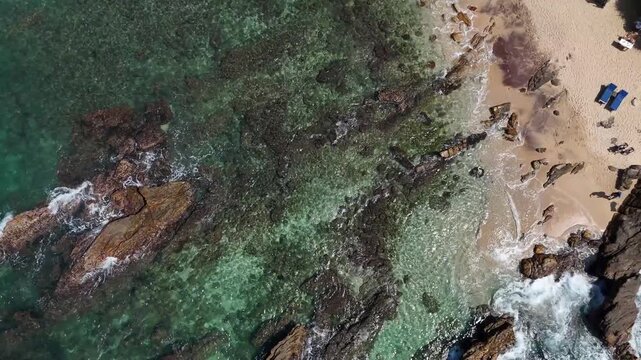 High angle aerial view of a rocky coast and a small section of a sandy beach. Mirissa, Sri Lanka