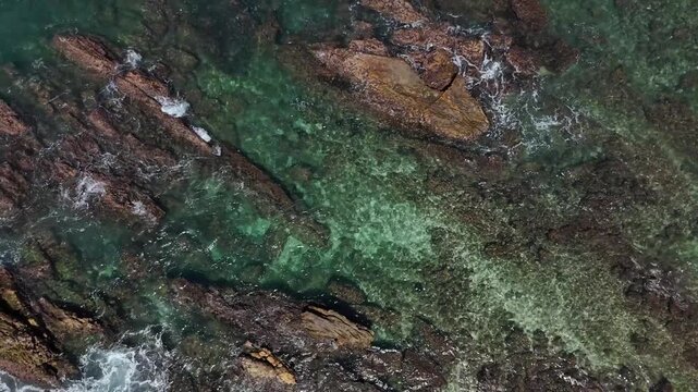 Top down drone footage of underwater rocks and transparent turquoise sea. Mirissa, Sri Lanka